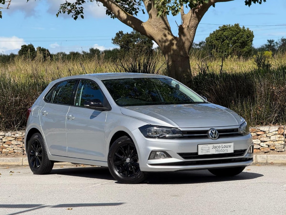 silver vw with trees and grass in the background